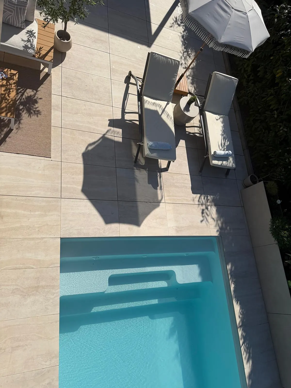 Terrasse et piscine vues d'en haut, dalles claires autour du bassin