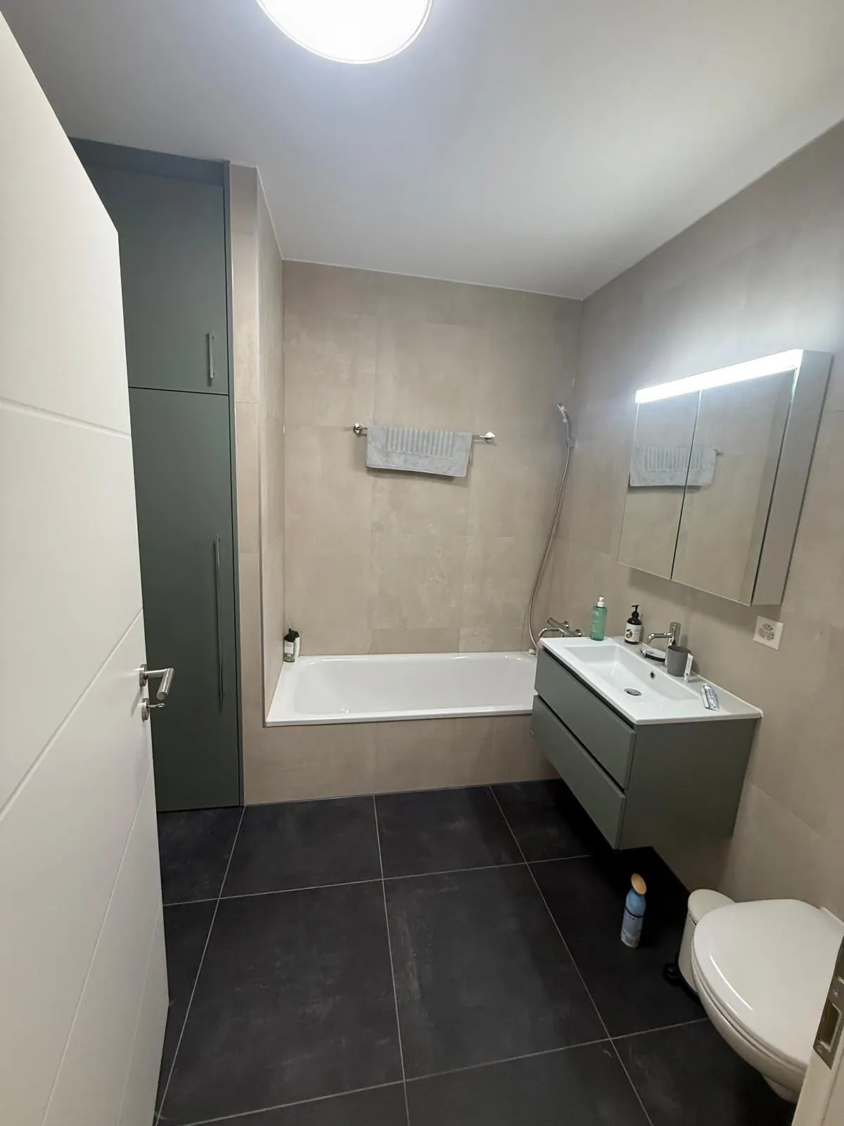 Salle de bain avec sol en carreaux anthracite et murs beiges