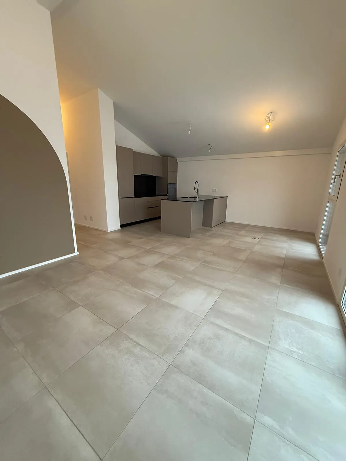 Grand espace ouvert carrelé en dalles beige grisé